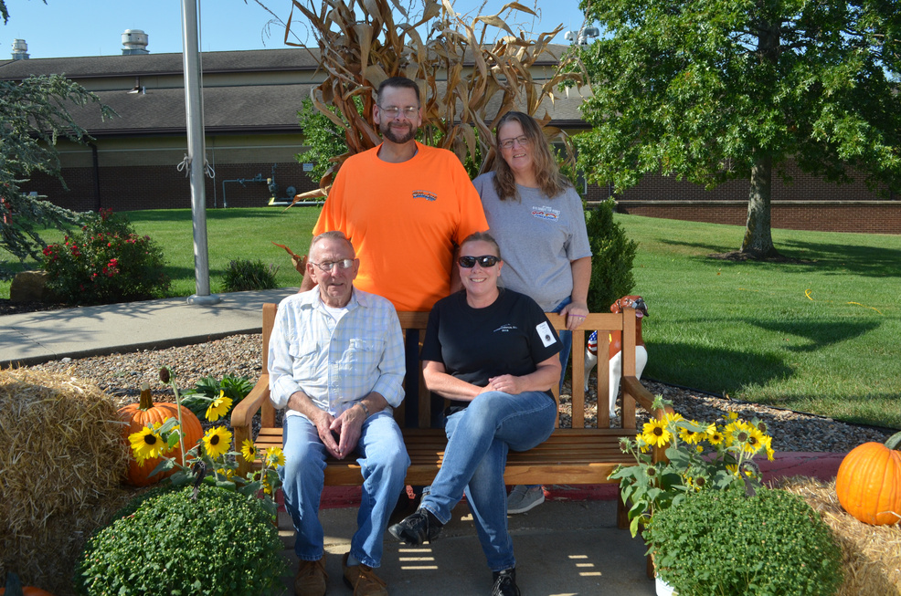 Family sitting on a bench with a smiling Veteran